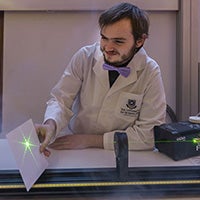 student demonstrating lasers